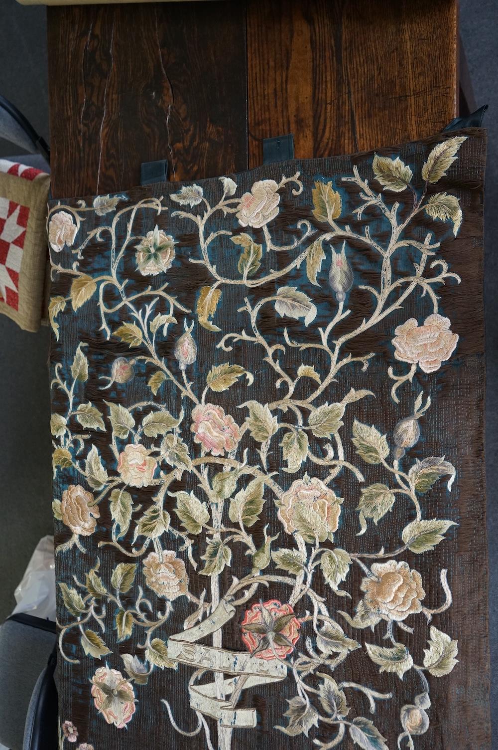 A large Arts and Crafts silk embroidered wall hanging, embroidered in the manner of May Morris with a large central scrolling flowering rose tree and banner embroidered with Salve and a two row motto below;, Rose leaves